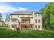 Rear exterior featuring a spacious lawn, a multi-level deck, and a covered patio for outdoor living at 3298 Alcovy Club Ct, Dacula, GA 30019
