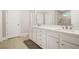 Bathroom with double sink vanity featuring white cabinets, stone countertops, and modern fixtures adding elegance and functionality to the space at 3298 Alcovy Club Ct, Dacula, GA 30019