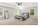 Spacious bedroom with tray ceilings, plush carpet, and windows at 3298 Alcovy Club Ct, Dacula, GA 30019
