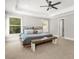 Bright bedroom featuring a tray ceiling, large windows, neutral walls and cozy carpeting, creating a serene and inviting atmosphere at 3298 Alcovy Club Ct, Dacula, GA 30019