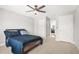 Well-lit bedroom with dark ceiling fan, neutral walls, and open doorway to an adjacent room at 3298 Alcovy Club Ct, Dacula, GA 30019