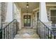 Inviting front porch with stone accents, iron railings, and a stylish double front door at 3298 Alcovy Club Ct, Dacula, GA 30019