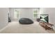 Inviting living room with a cozy beanbag chair, large windows, and a television for a relaxing and entertaining atmosphere at 3298 Alcovy Club Ct, Dacula, GA 30019
