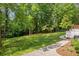 Lush backyard featuring mature trees, green lawn, and a stone walkway, offering a serene outdoor space at 4331 E Kings Point Circle, Dunwoody, GA 30338
