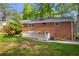 Backyard view of a brick home with a patio, fenced yard, and lush greenery, ideal for outdoor enjoyment at 4331 E Kings Point Circle, Dunwoody, GA 30338