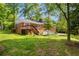 Exterior backyard view of a home showing the yard, brick exterior, deck, and mature trees at 4331 E Kings Point Circle, Dunwoody, GA 30338