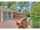 View of a home's backyard showing a spacious deck, brick exterior, and mature trees at 4331 E Kings Point Circle, Dunwoody, GA 30338