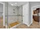 Bright bathroom featuring a tiled shower, pebble floor accent, and seamless glass door at 4331 E Kings Point Circle, Dunwoody, GA 30338