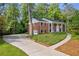 Brick home with attached garage and long driveway lined with manicured landscaping at 4331 E Kings Point Circle, Dunwoody, GA 30338