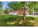 Back view of brick home with a large yard, deck, and a two car garage at 4331 E Kings Point Circle, Dunwoody, GA 30338