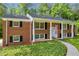 Charming two-story brick home featuring classic architecture, black shutters, and a welcoming front porch at 4331 E Kings Point Circle, Dunwoody, GA 30338