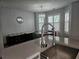 Open dining area featuring a glass table, cushioned bench, and unique light fixture at 5536 Strathmoor Manor Cir, Lithonia, GA 30058