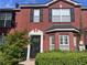 Charming two-story brick townhouse with black shutters, decorative door, and well-maintained landscaping at 5536 Strathmoor Manor Cir, Lithonia, GA 30058