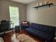 Bright home office with desk, blue futon, chair, and natural light at 5536 Strathmoor Manor Cir, Lithonia, GA 30058