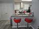 Modern kitchen features a breakfast bar with red bar stools and stainless steel appliances at 5536 Strathmoor Manor Cir, Lithonia, GA 30058