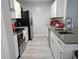 Well-equipped kitchen featuring stainless steel appliances, white cabinets, and gray countertops at 5536 Strathmoor Manor Cir, Lithonia, GA 30058