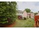 Backyard view showing deck, green grass, trees, and townhomes at 7812 Kiverton Pl, Atlanta, GA 30350