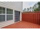 Spacious wood deck with red-painted wood railing off the back of the home at 7812 Kiverton Pl, Atlanta, GA 30350