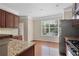 Kitchen boasts hardwood floors, granite countertops, stainless appliances, and a sunny breakfast nook at 7812 Kiverton Pl, Atlanta, GA 30350