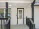 Inviting covered entryway boasting a white door with decorative glass and black trim at 117 Spring St, Stockbridge, GA 30281