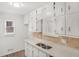 Updated kitchen with white cabinets, dual sink, and warm backsplash at 117 Spring St, Stockbridge, GA 30281