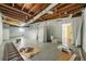 Unfinished basement with exposed wood ceiling, white walls, and concrete flooring, ready for customization and renovation at 2703 Flagstone Se Dr, Atlanta, GA 30316