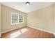 A simple bedroom with hardwood floors, a window, and beige walls at 2703 Flagstone Se Dr, Atlanta, GA 30316