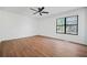 This spacious bedroom features wood floors, a ceiling fan, and a window at 3813 Nowlin Nw Rd, Kennesaw, GA 30144