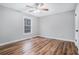 Comfortable bedroom featuring laminate floors, a ceiling fan, neutral paint, and a view of the backyard at 441 Village Way, Lawrenceville, GA 30046