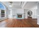 Sunlit living room features hardwood floors, a cozy fireplace, and detailed ceiling trim and a large window at 441 Village Way, Lawrenceville, GA 30046