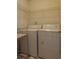 Efficient laundry area with washer, dryer, and storage shelf at 442 John Stewart Pl, Suwanee, GA 30024