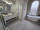 Bright bathroom features double vanity, stylish soaking tub, and decorative stained glass window at 7910 Tintern Trce, Duluth, GA 30097