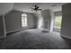 Spacious bedroom with carpet flooring, a ceiling fan, windows, and unique architectural details at 7910 Tintern Trce, Duluth, GA 30097