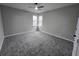 A cozy bedroom with carpet flooring, a ceiling fan, and windows that provide natural light at 7910 Tintern Trce, Duluth, GA 30097