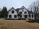 Stunning two-story home with a black roof, white facade, manicured lawn, and circular driveway at 7910 Tintern Trce, Duluth, GA 30097