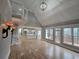 Sunlit living room features hardwood floors, a vaulted ceiling, built-in shelving, and access to the kitchen at 7910 Tintern Trce, Duluth, GA 30097