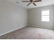 Neutral bedroom with a ceiling fan, window, and comfortable carpet flooring at 2172 Red Rose Ln, Loganville, GA 30052