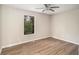 Cozy bedroom featuring hardwood floors, a window view of the trees, and a ceiling fan at 336 Rockmoor Trl, Marietta, GA 30066