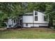 Contemporary home featuring modern design, white siding, black trim, nestled within a lush, wooded landscape at 336 Rockmoor Trl, Marietta, GA 30066