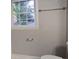 Neutral bathroom with a window, grab bar, towel bar, and a white toilet at 409 Arbor Ridge Dr, Stone Mountain, GA 30087