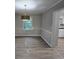 Dining room featuring gray walls, white trim, wood-look flooring, and a stylish light fixture at 409 Arbor Ridge Dr, Stone Mountain, GA 30087