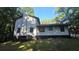 View of the home's exterior elevation, with a full view of the backyard and chimney at 409 Arbor Ridge Dr, Stone Mountain, GA 30087