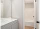 Bright bathroom featuring a gray vanity, large mirror, and a shower/tub with white tile surround at 4902 Cedar Se Ct, Conyers, GA 30094