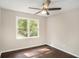 Cozy bedroom with hardwood floors, a ceiling fan, and a large window with backyard view at 4902 Cedar Se Ct, Conyers, GA 30094