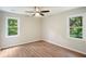 Bright bedroom featuring wood floors, neutral walls, and two windows with wooded view at 3333 Devaughn Ne Dr, Marietta, GA 30066