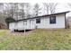 Home's backyard featuring a deck, lawn and wooded surrounding at 3436 Lake Monroe Rd, Douglasville, GA 30135