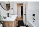 Stylishly renovated bathroom featuring white subway tile, matte black hardware, and a sleek wood vanity at 4529 Lakeview Dr, Powder Springs, GA 30127