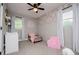Bright bedroom with floral wallpaper accent wall, complemented by light gray walls and a plush pink chair at 4529 Lakeview Dr, Powder Springs, GA 30127