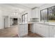 Well-lit kitchen with white cabinets, granite countertops, and a view into the living area at 5444 Wylstream, Norcross, GA 30093