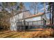 Rear exterior featuring a deck with railing, a sloped yard with trees and fall foliage at 7935 Sweetwater Dr, Douglasville, GA 30135
